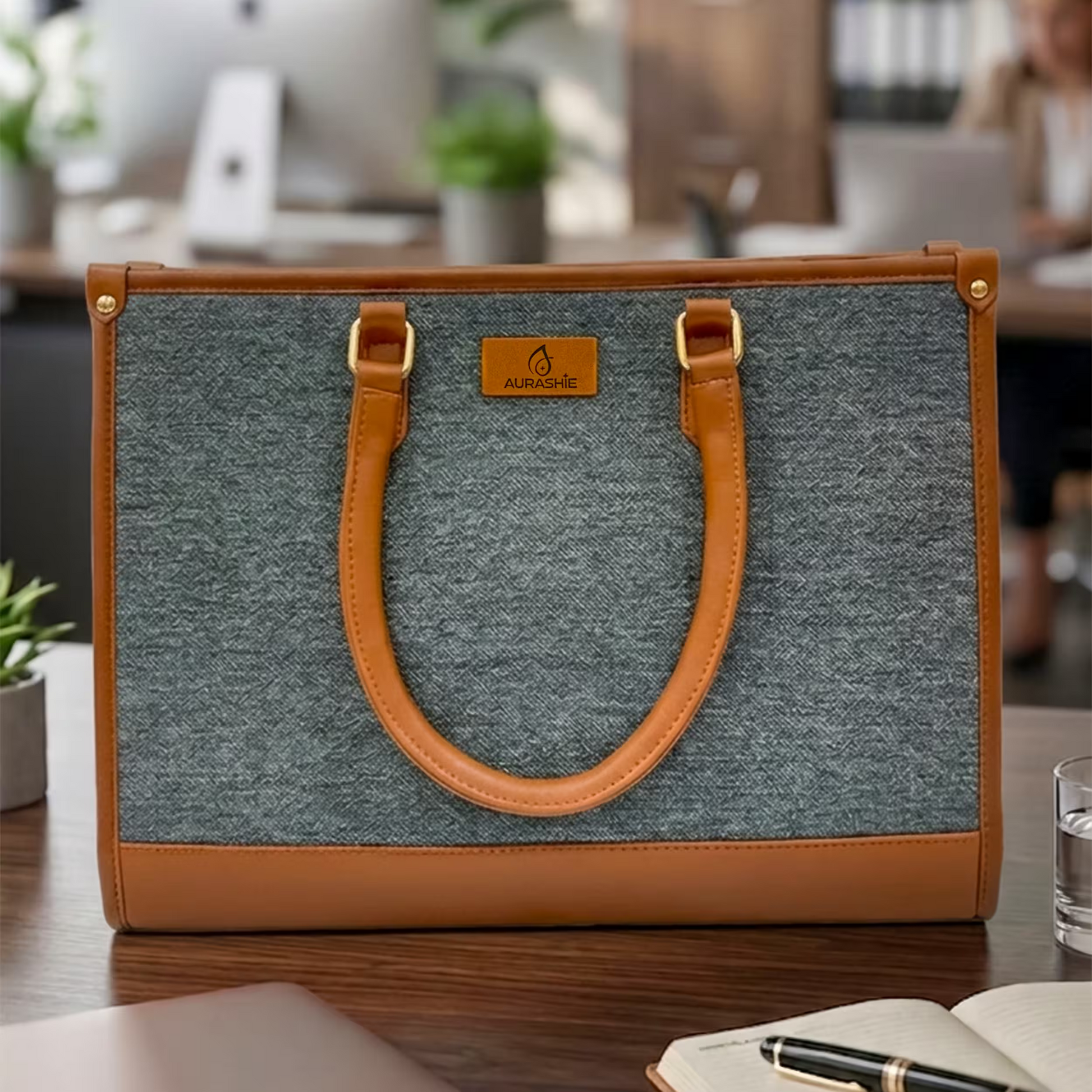 Gray and brown handbag on a desk with a blurred office background