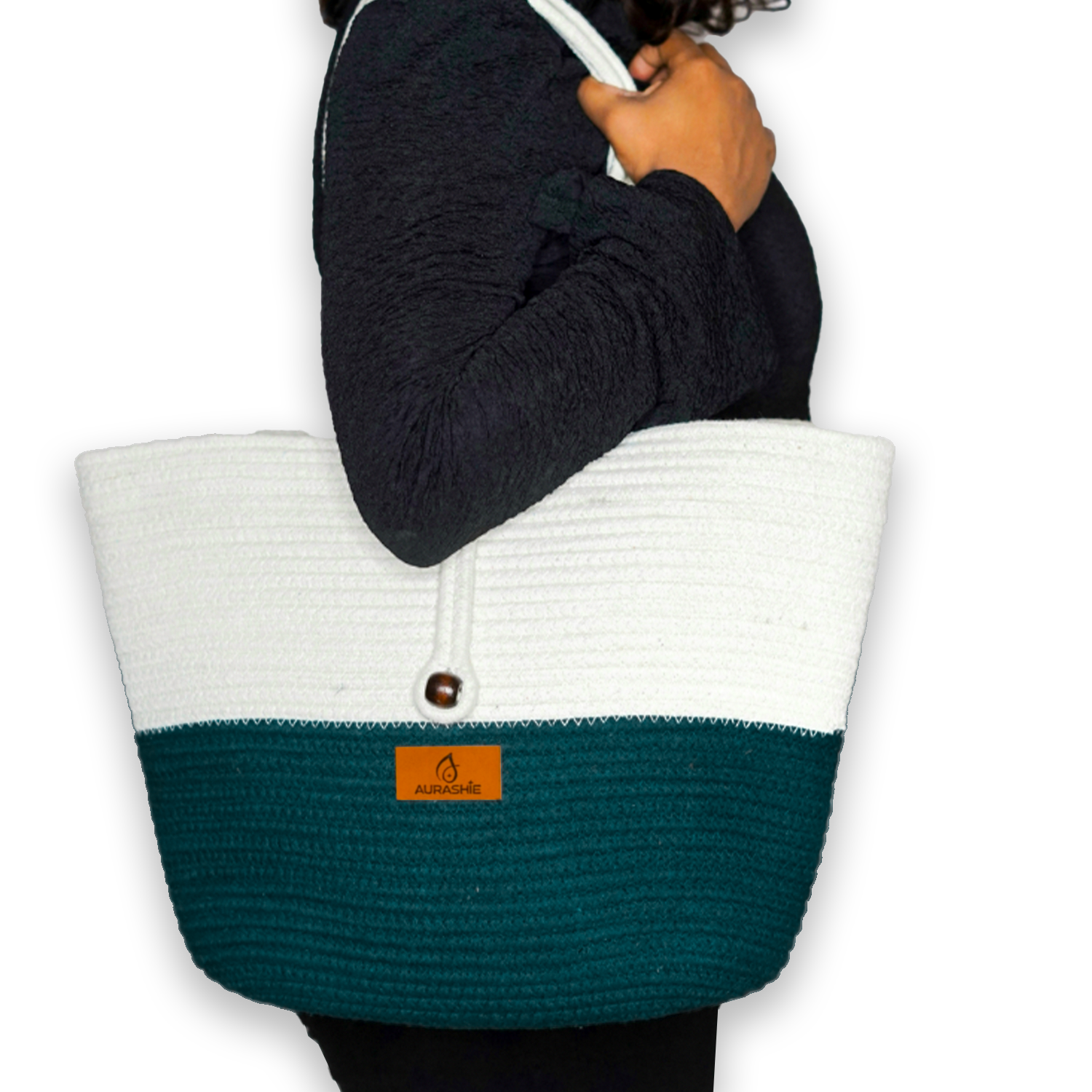 Person holding a white and teal tote bag with a visible brand logo on a white background