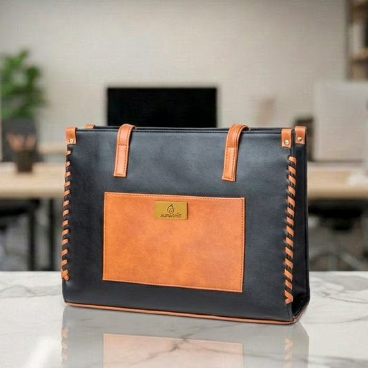Black and brown leather bag on a marble surface with a blurred office background