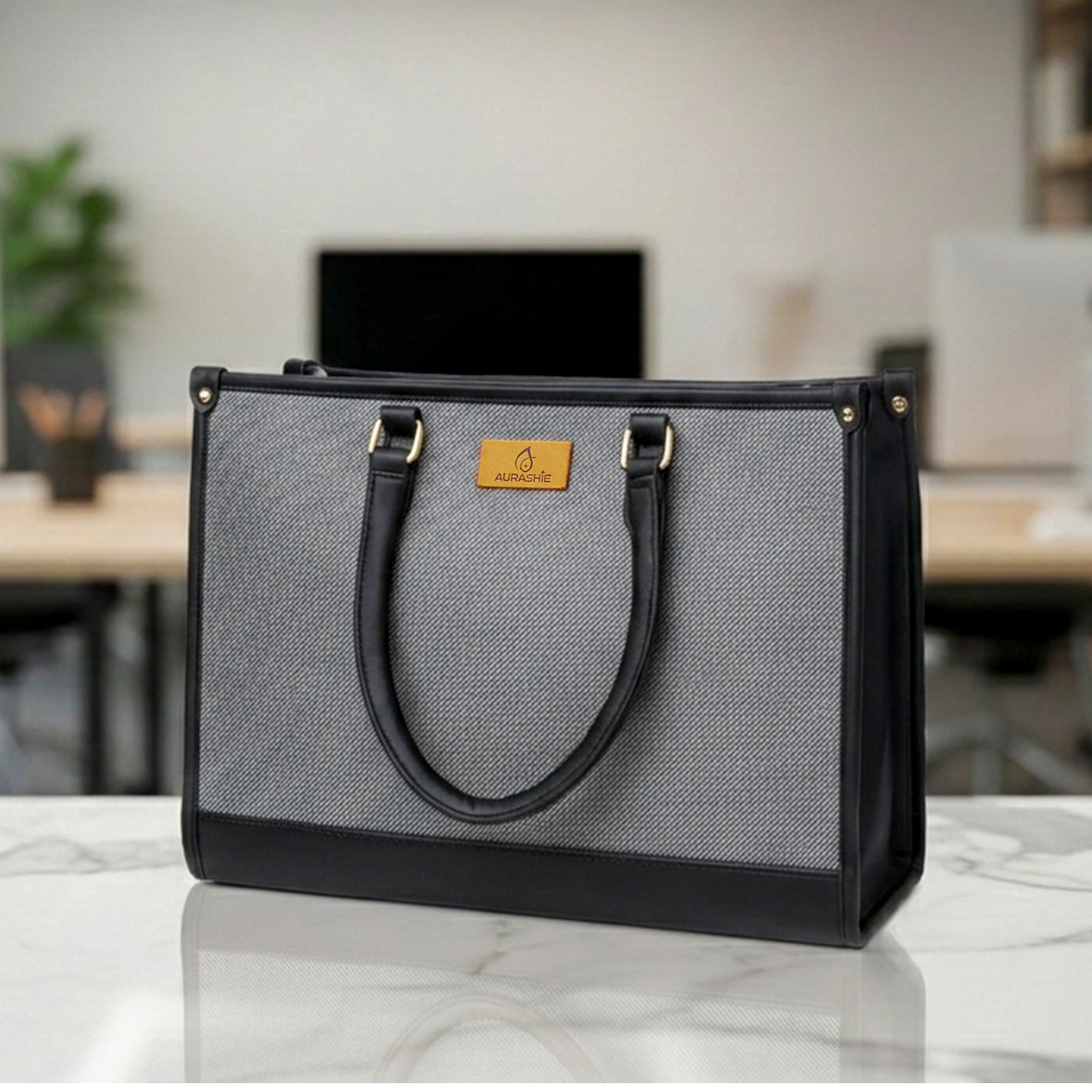 Gray and black bag with a brand logo on a marble surface in an office setting