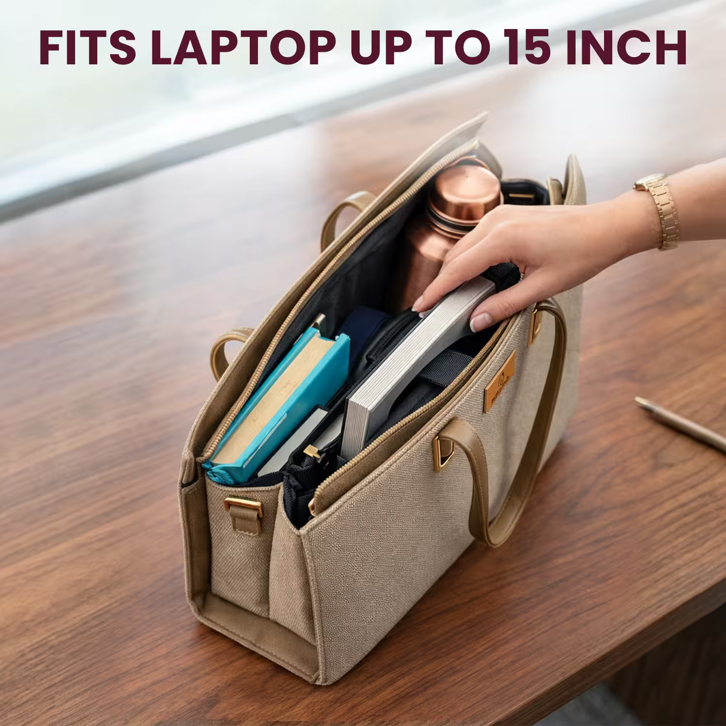 Beige laptop bag with compartments on a wooden surface, containing items like a blue notebook and silver laptop.