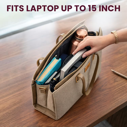 Beige laptop bag with compartments on a wooden surface, containing items like a blue notebook and silver laptop.