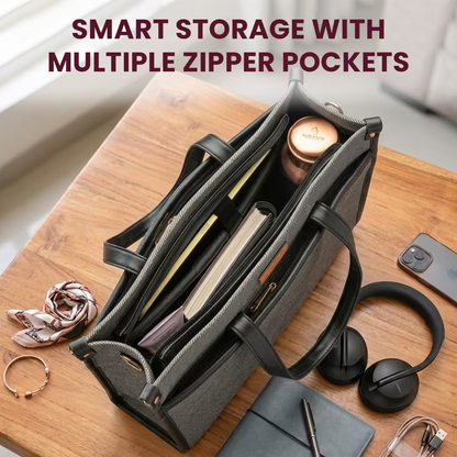 Black bag with multiple zipper pockets on a wooden surface, containing a phone, headphones, and other items.
