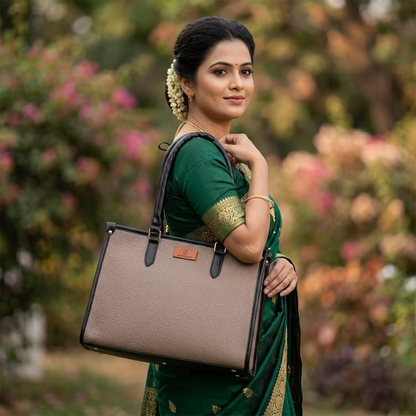 Woman in a green saree holding a beige handbag with a blurred floral background