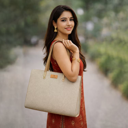 Woman holding a beige handbag outdoors with a blurred natural background